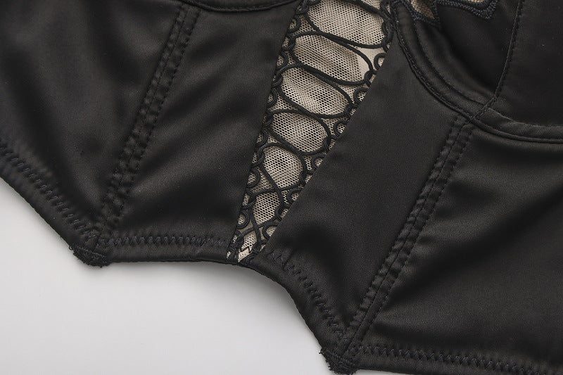 Close-up of the architectural lace-up front and sheer mesh panel on the Sage Aeris bra, black.