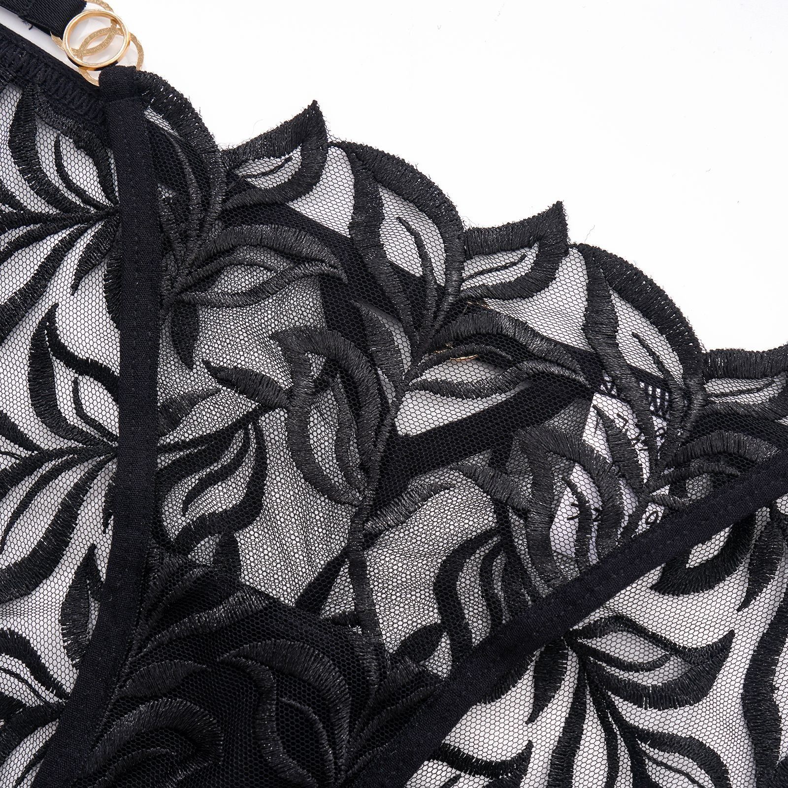 Macro shot of the "line art" botanical embroidery on high-clarity sheer mesh, black.