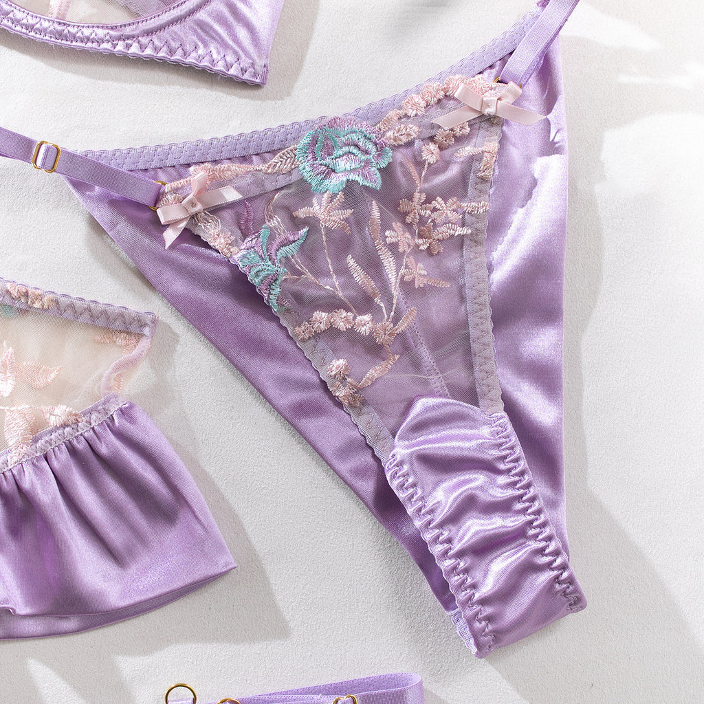A macro view of the floral embroidery on the front of the set. Highlighting the 3D-effect of the lace appliqués in shades of lilac and mint.