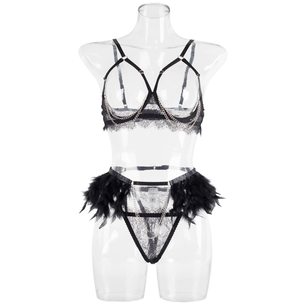 Front view on a transparent mannequin, illustrating the "floating" effect of the open-cup bra and the feather-adorned waistline.