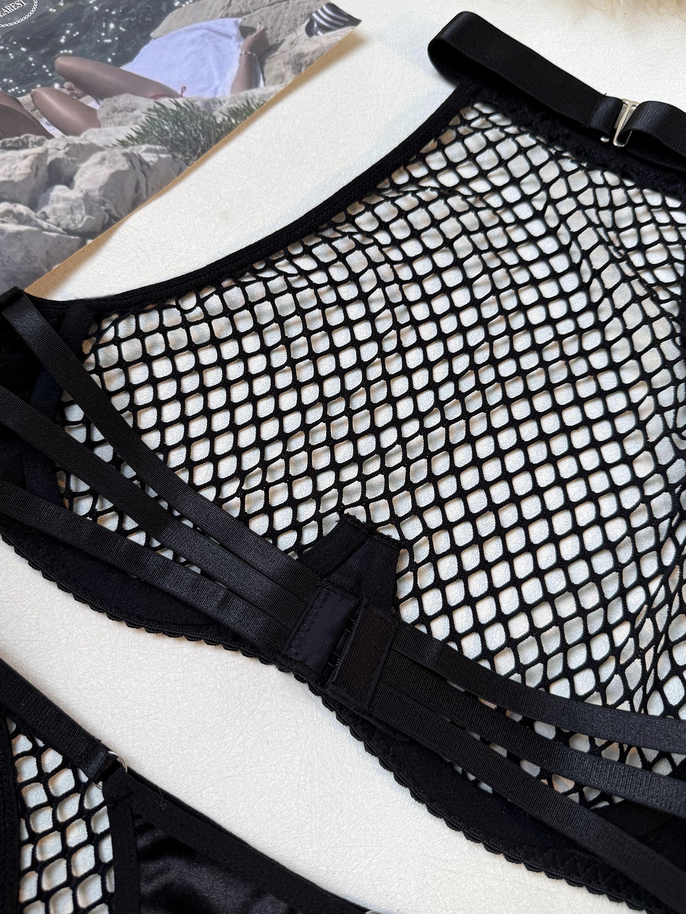 A tactile study of the obsidian net and satin trim, capturing the unshielded intensity and fearless beauty of the Cold Burn mood.