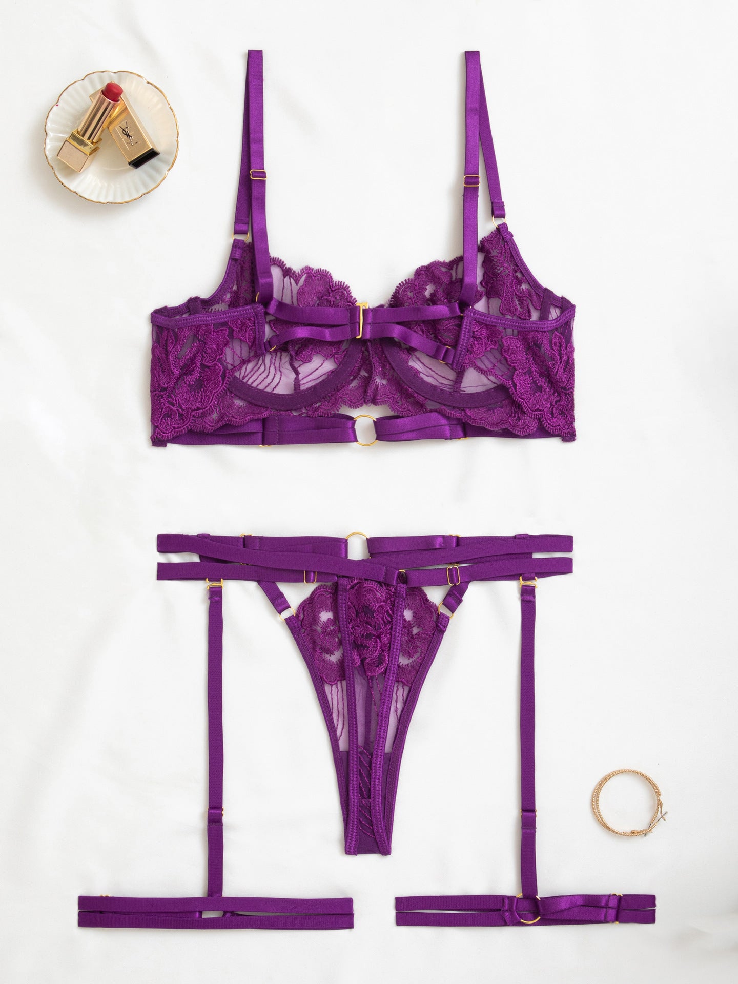 Rear view of the purple garter harness and strappy thong with gold hardware.