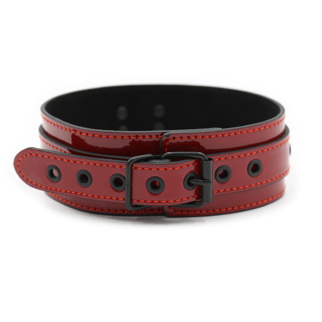 A structured red patent leather collar with a high-gloss finish and adjustable black buckle closure from the After Dark collection.
