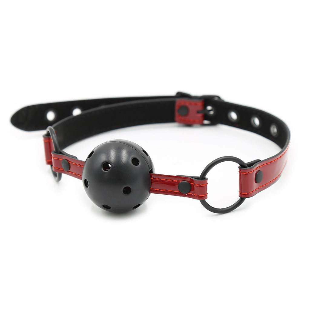 Ergonomic ball gag featuring a high-gloss red patent leather strap, adjustable buckle, and breathable black silicone ball.