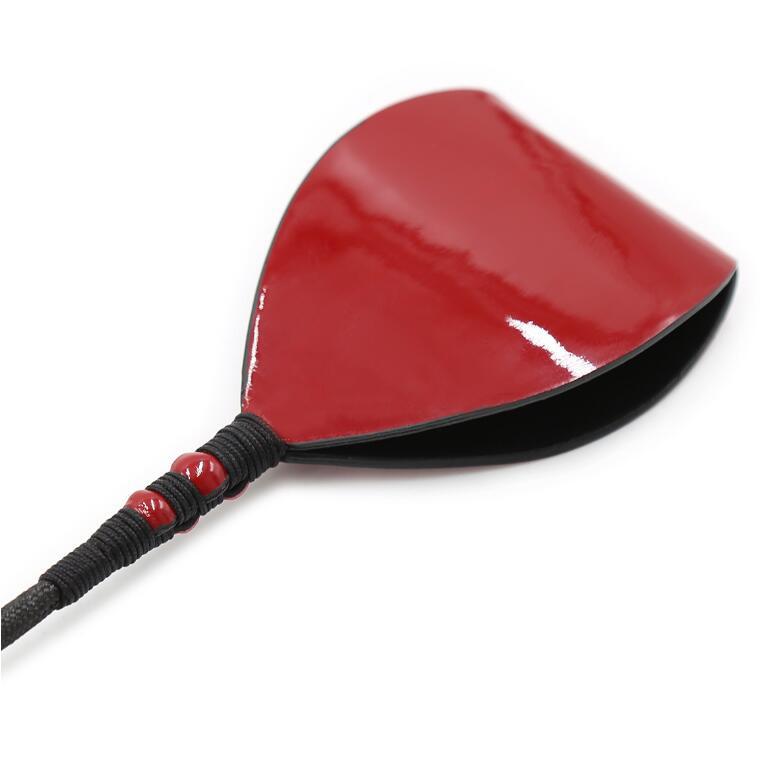 Close-up of the broad, dual-layered red patent leather tip designed for a sharp aesthetic and deliberate tactile impact.