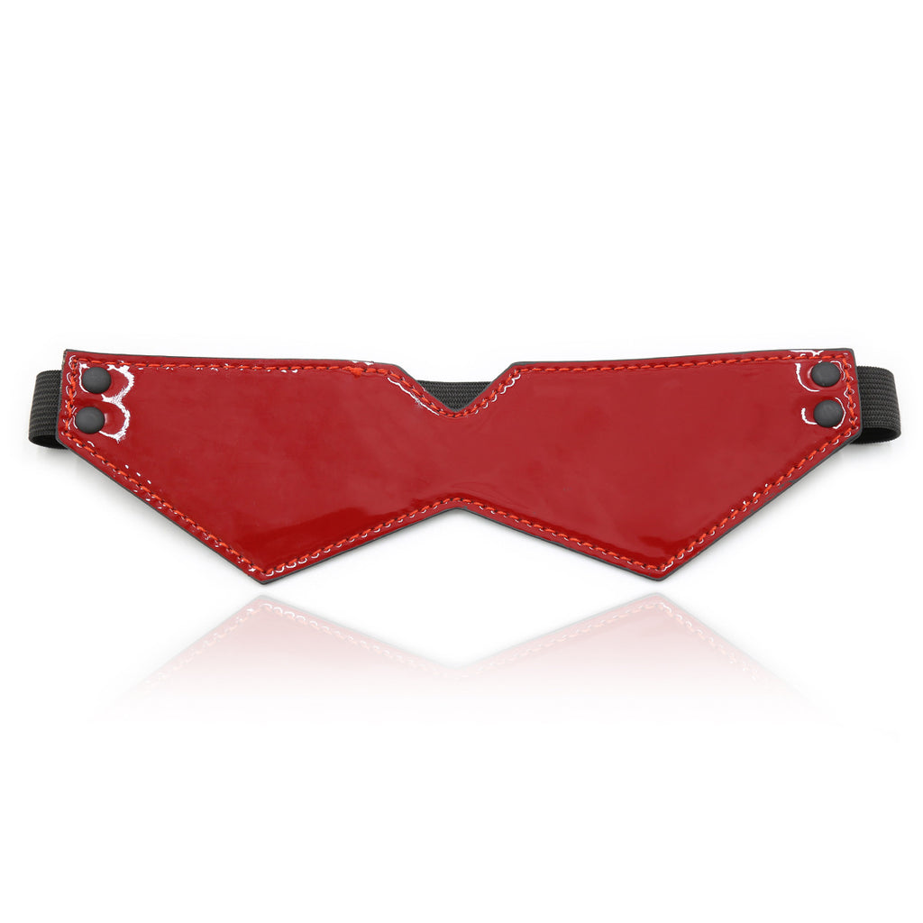 A minimalist, geometric eye mask in high-gloss red patent leather with a comfortable elasticated strap for sensory deprivation.