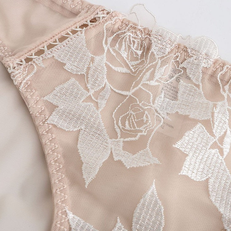 Detailed close-up of the white-on-nude floral rose embroidery.