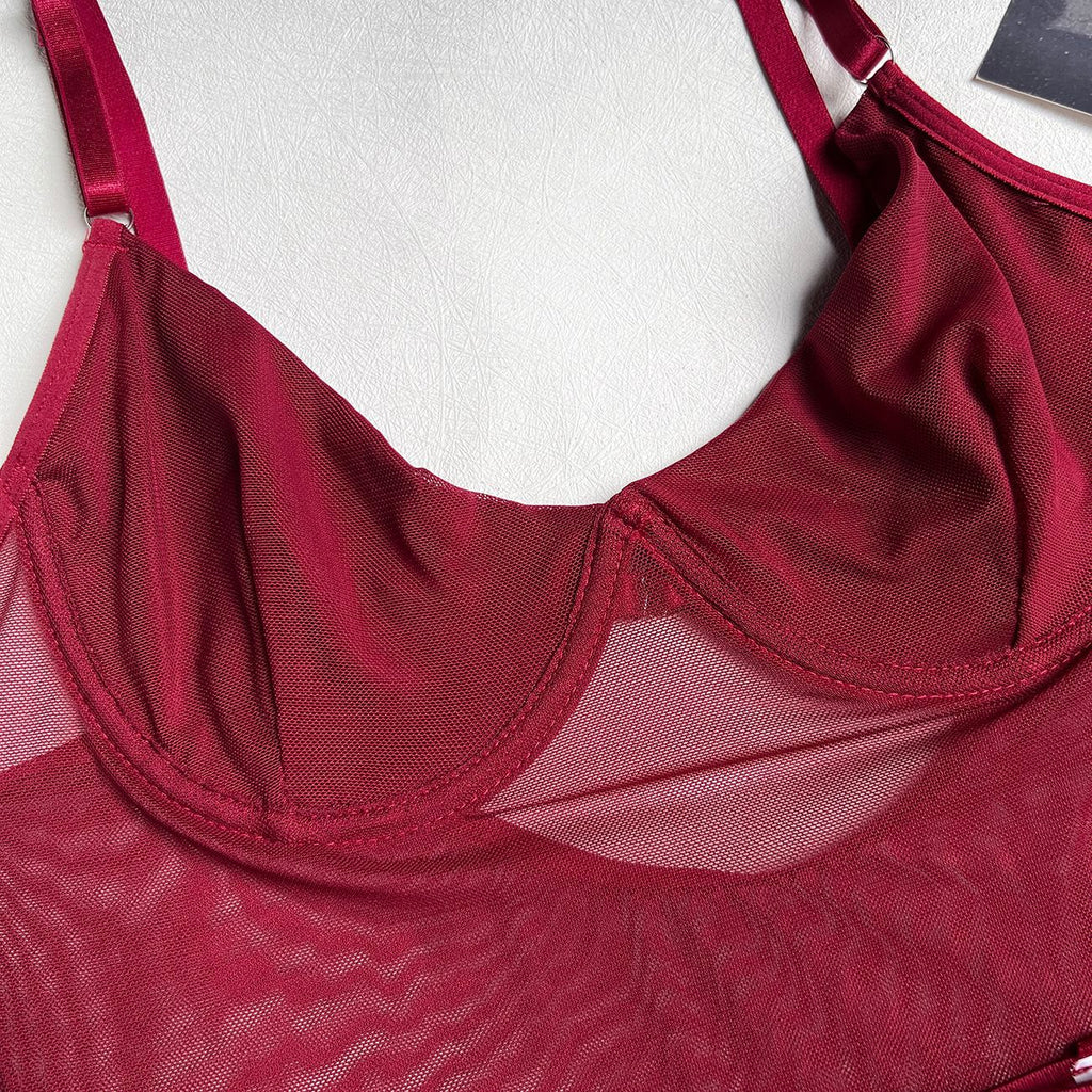 An intimate close-up of the sheer burgundy power-mesh, showcasing the vertical cup seaming and the delicate transparency of the bodysuit.