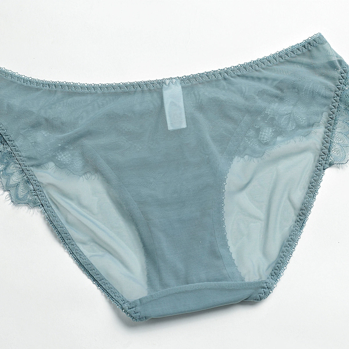 Rear view of floral lace texture and sheer mesh construction showing stretch and fine craftsmanship. 
