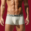Front view of the Arctic Sand cotton trunk against a signature mooods burgundy background, highlighting the ribbed texture and slate waistband.