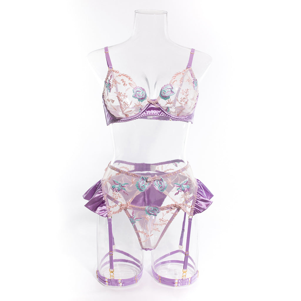 A clear front-view studio shot on a mannequin. Showcasing the unlined underwired bra architecture and the symmetry of the watercolor floral embroidery.