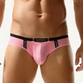 Frontal view of an athlete in vibrant pink nylon mesh briefs with signature metal hardware.
