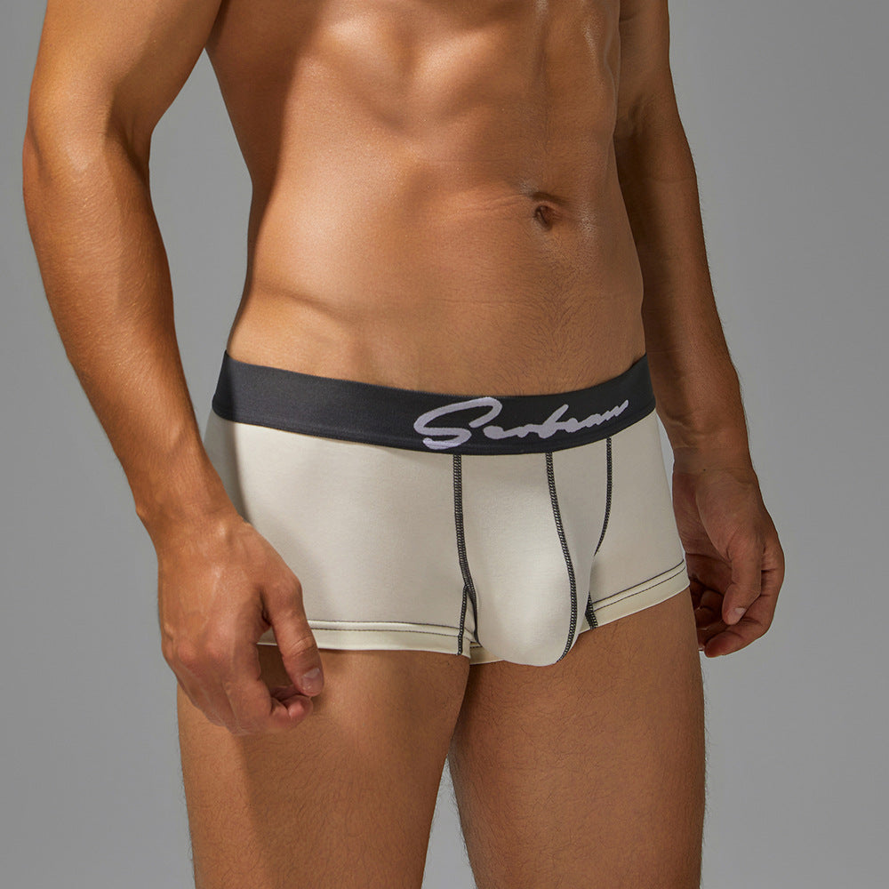 45-degree angle of white cotton trunks on a male model, showcasing the supportive bridge pouch.
