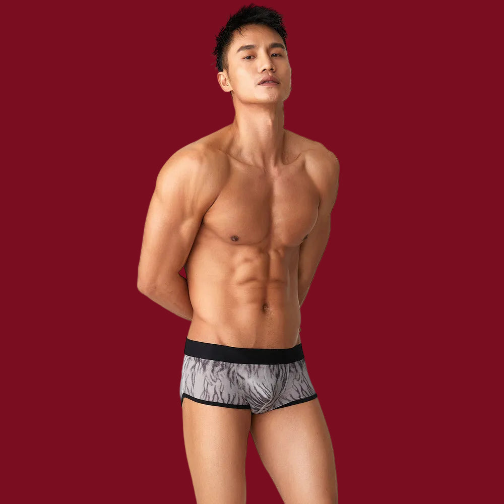 A three-quarter studio pose on a burgundy backdrop, showcasing the body-sculpting fit and modern silhouette of the ash-grey tiger print.